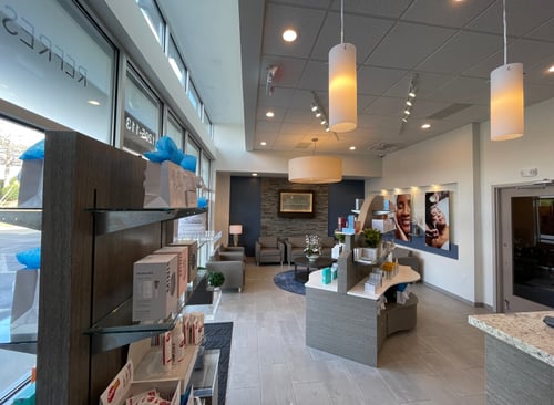 Hand & Stone reception desk with stone textures and welcoming lighting near the entrance.
