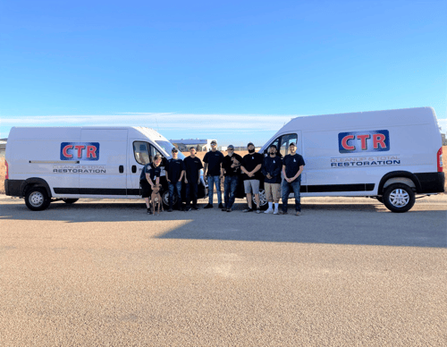 Cleanup & Total Restoration team standing in fornt of trucks