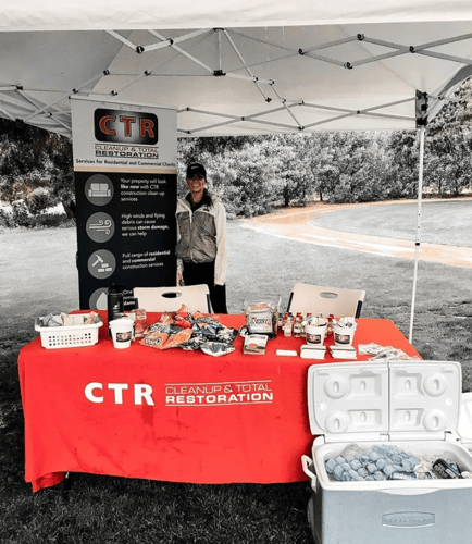 CTR Team member standing in the Idaho winter cold underneath a CTR Tent featuring information and gifts