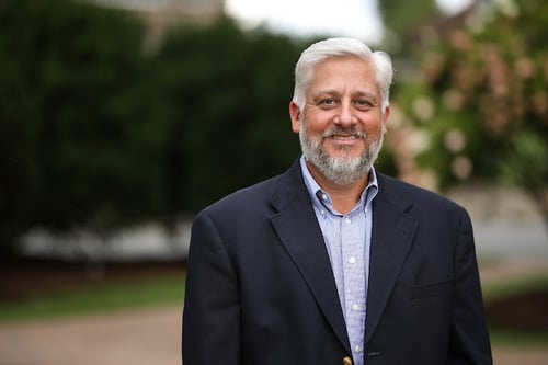 Agent Tyler Hunter standing and smiling wearing blue button up shirt and navy blue blazer