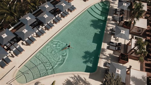 A swimmer enjoys the clear waters of a Four Seasons Hotel pool.