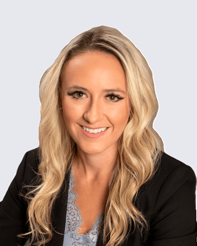 A blonde woman smiling in a suit.
