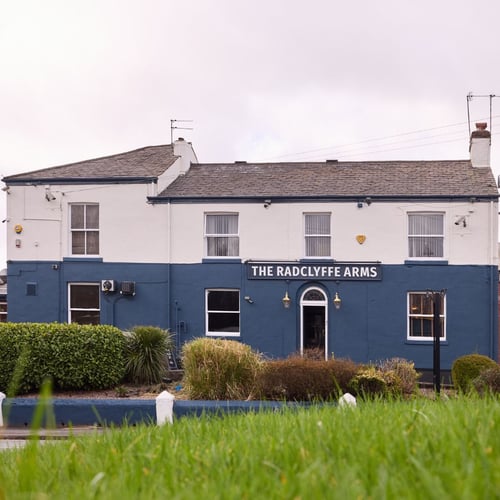 Exterior of The Radclyffe Arms with entrance and signage