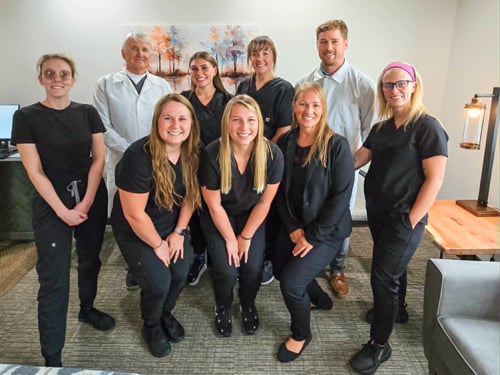 Dentists and dental team members from MI Smiles Dental Comstock Park posing together inside the office.