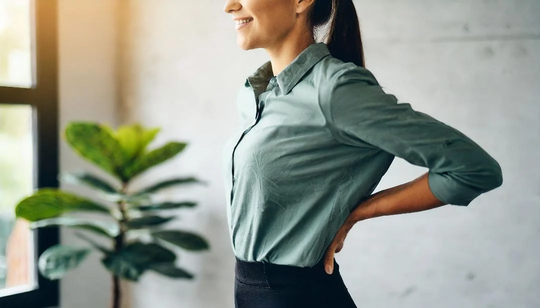 woman holding her back smiling because of relieved back pain