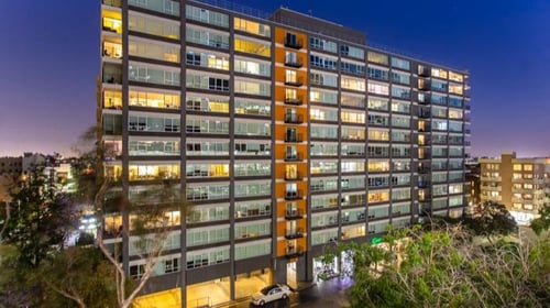 A tall building with many windows is lit up at night at The View, Los Angeles