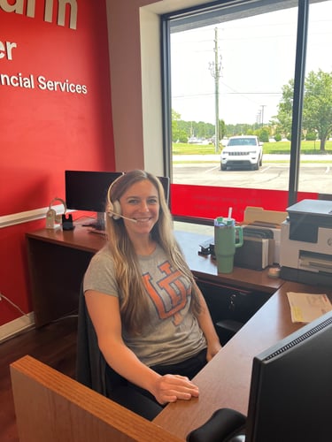 A team member of the Matt Collier State Farm Agency in a football t-shirt at her desk