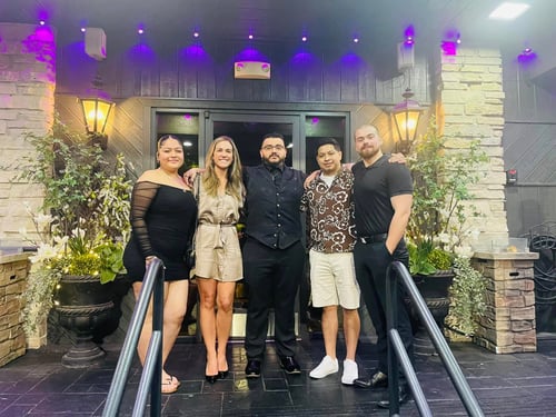 Agent Stefanie and four team members standing and smiling together outside of restaurant