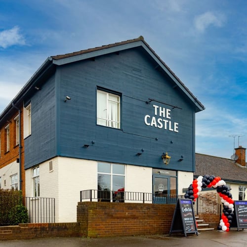 Exterior of The Castle pub with entrance and signage