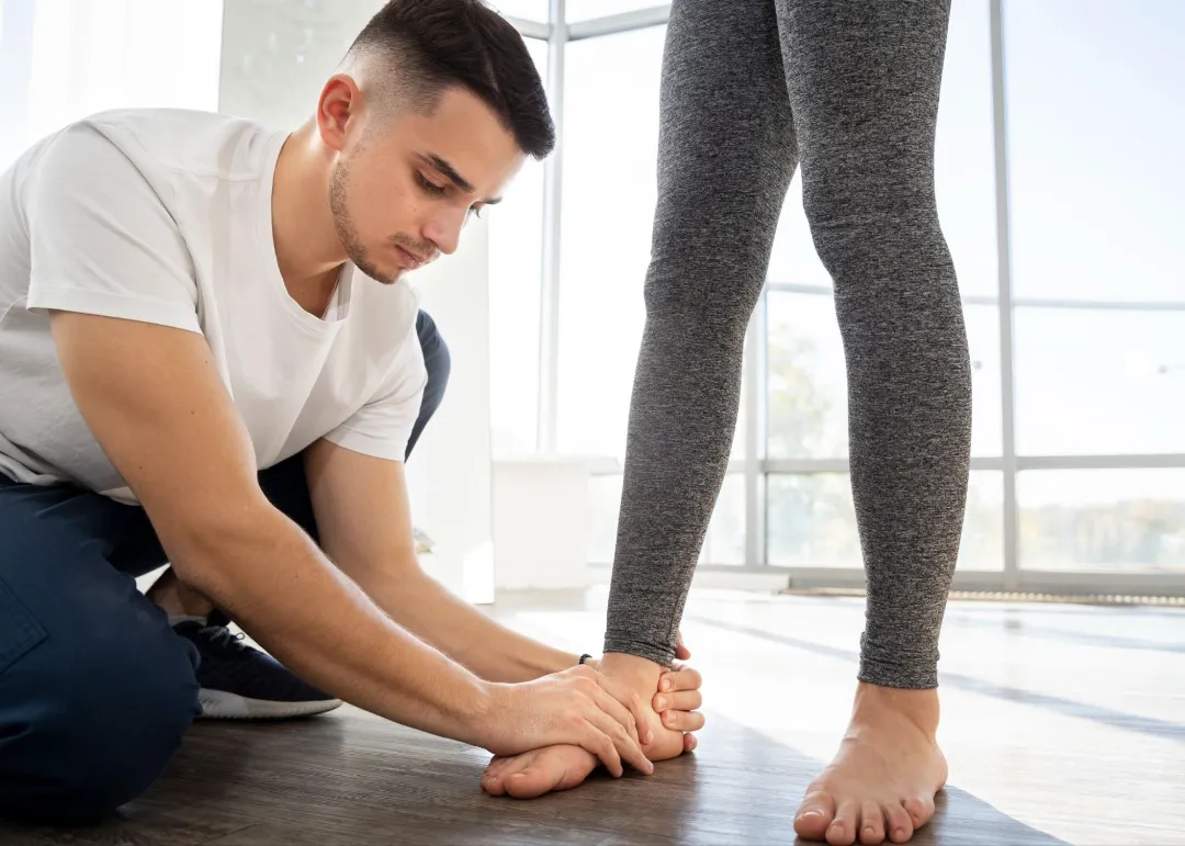 arch support specialist examining a woman's foot while standing