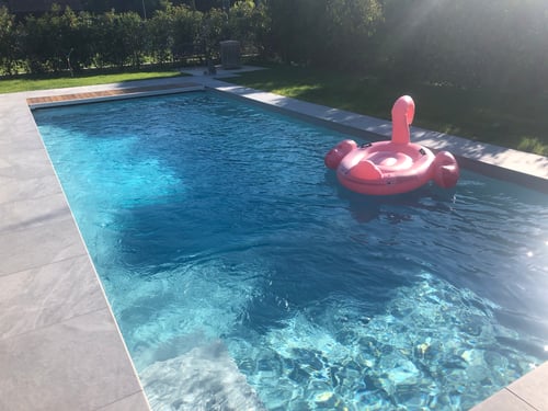 Piscine de 11,00 x 4,00 mètres, liner gris clair, volet immergé avec lames PVC coloris gris et caillebotis bois