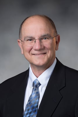 Dr. Wilde smiling in front of a gray background.