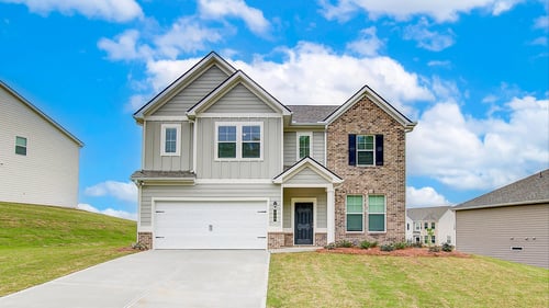 Two story home with brick and tan siding with two car garage in DRB Homes Westminster community