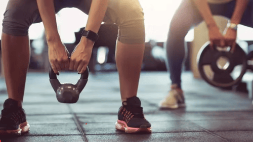 two people lifting weights during a training session