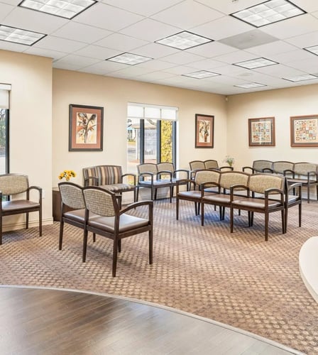 The lobby for the dental office, it has plenty of comfortable seating and nice art hanging on the walls.
