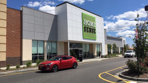Red car passing front entrance of Home Sense at The Shops at Riverhead shopping center