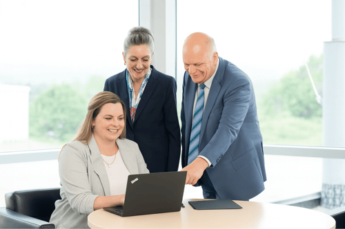 Katie, Janine and Steve working around a laptop.