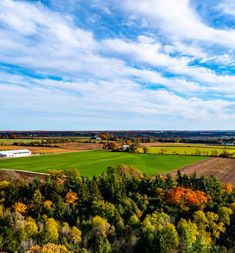 A beautiful farmland in autumn with a cloudy blue sky.
