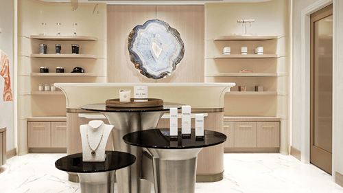 Luxurious spa with modern decor, a central display of skincare products and jewelry, soft lighting and a large agate wall accent