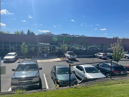 Green exterior storefront sign of MUV Fitness Tanasbourne gym in Beaverton during the day.