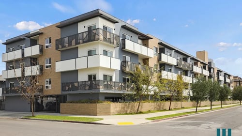 Apartment building with balconies and a clear sky.