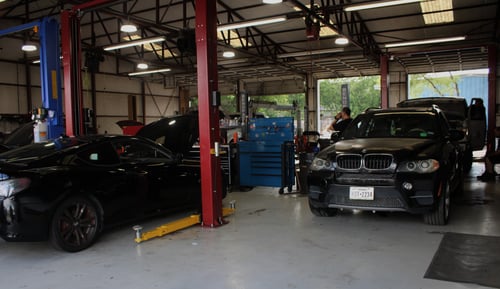 Interior of Willard Automotive’s repair shop with multiple service bays and vehicles in Grapevine, TX.