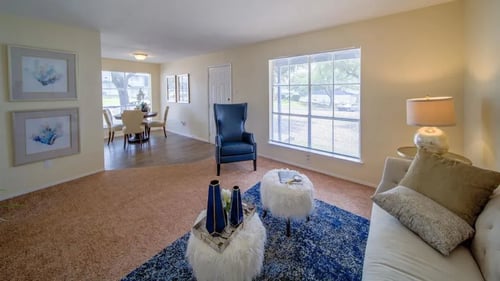 A living room with a couch and a table at Villas del Tesoro Apartments, Texas, 75228