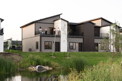 Rialto Townhomes building with a green space and lake in front of it, Waukee, IA