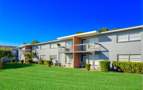 exterior of building with green lawn at Hibiscus Place in Orlando, FL