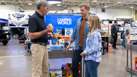 couple talking with a worker inside of a camping world retail store