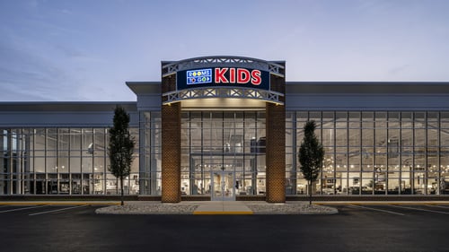 Rooms To Go Kids store exterior in Newport News, VA, displaying a modern glass facade and inviting entrance at dusk