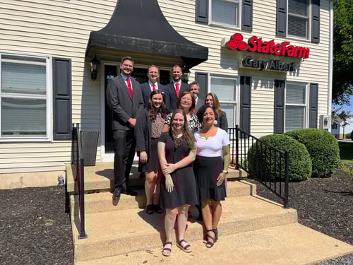 Agent Gary standing and smiling with team members