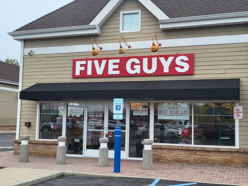 Exterior photograph of the Five Guys restaurant at 855 Montauk Highway in Shirley, New York.