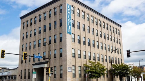A Lee Lofts building is shown with a blue sign on the side at Lee Lofts, Minneapolis, MN, 55401