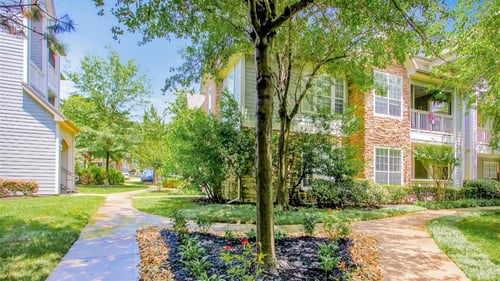 Exterior apartment walkway with trees at Remington at Memorial Apartments, Tulsa, OK