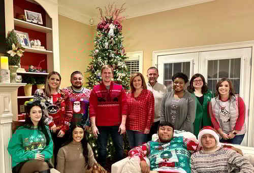 Agent Melissa and eleven team members standing and smiling together celebrating Christmas