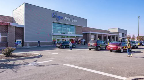 People walking past parked cars towards Kroger entrance at Stony Brook shopping center