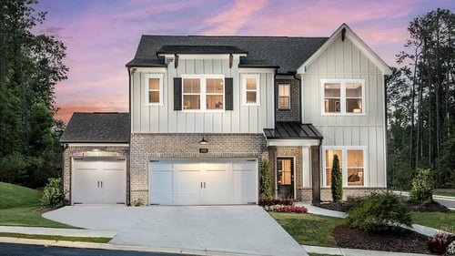 two-story home with white siding and three-car garage