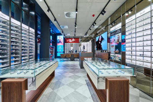Vision Express optikai üzlet belső tere Budapesten, szemüveg vitrinek és prémium márkák.