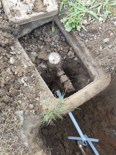water meter partially buried inside yard box.