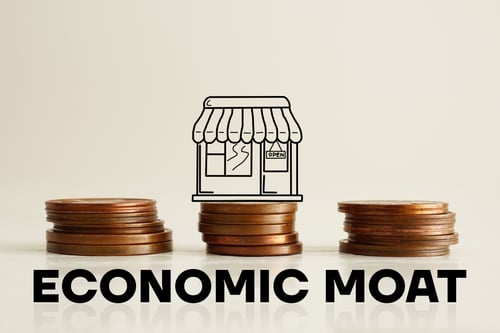 Coins stacked in three piles with a graphic drawing of a shop sitting on the middle pile.