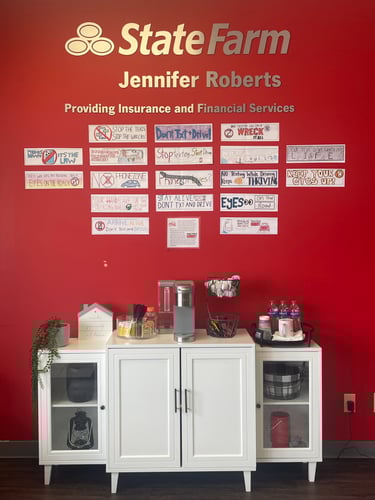 Red wall with hand drawn cards and a silver sign above with white cabinetry below.