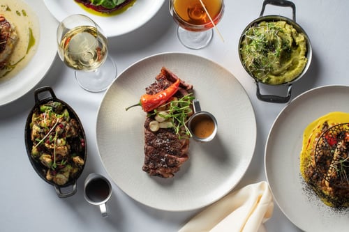 Steak dish with various dishes of food