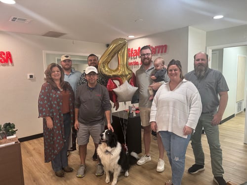 Team photo with a ballon in the shape of a 4.