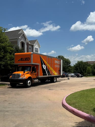 Orange moving truck parked in front of apartment complex