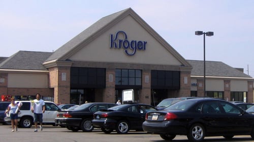 People walking through full parking lot of Kroger