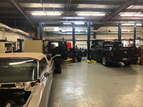 Interior of Willard Automotive Lewisville repair shop with vehicles in service bays