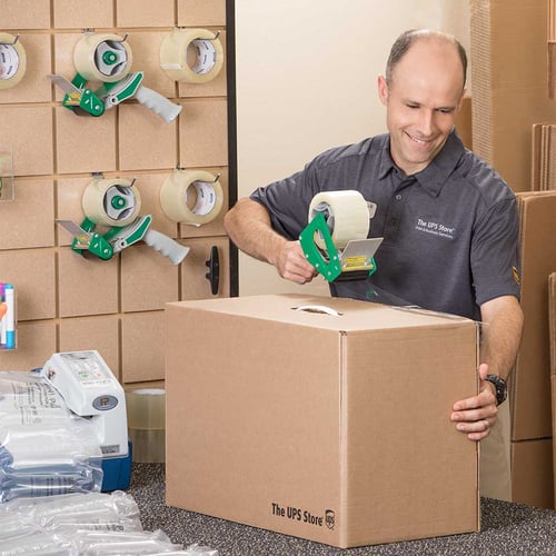 The UPS Store franchisee taping a shipping box