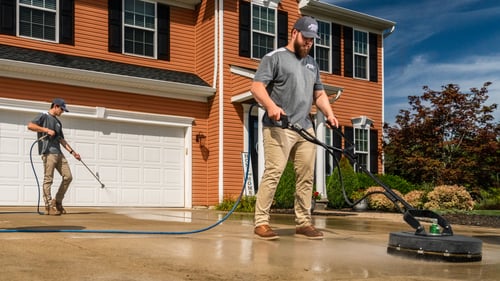 Pristine Clean worker cleaning and sealing driveway