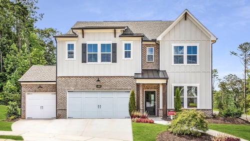 front of two-story home with white siding and 3rd car garage